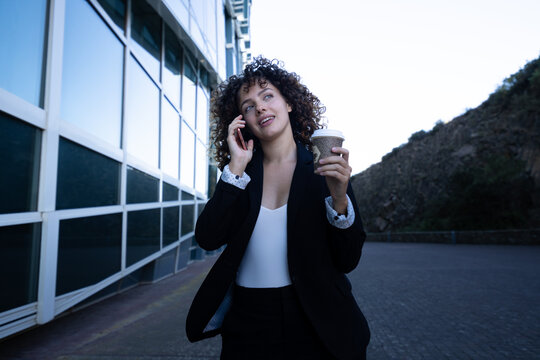 Businesswoman holding coffee cup and talking on phone