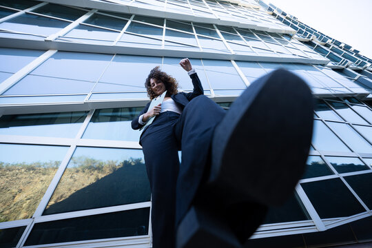 Businesswoman stepping forward in front of glass office building