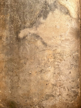 Weathered beige plaster wall texture with subtle cracks and natural water stains