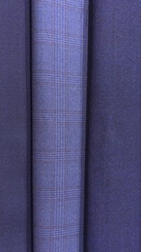 Vertical shot of premium blue and gray plaid suit fabrics in store