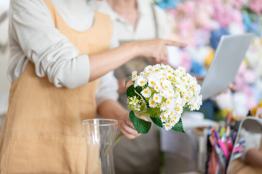 florist flower arrangement daisy bouquet hand pointing vase laptop apron shop business work craft