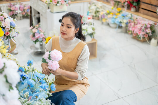florist shop woman in apron sitting with peony bouquet arrangement asian retail store business work