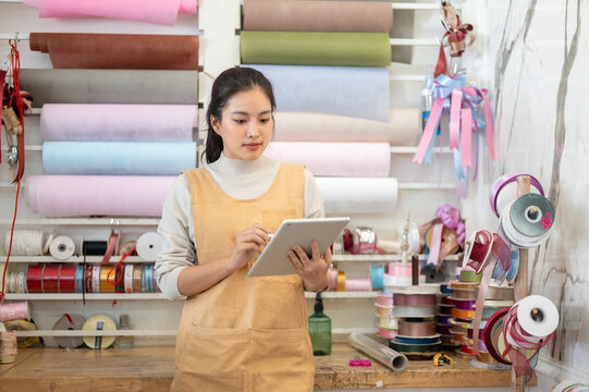 florist shop woman in apron holding a tablet business work inventory asian store office management
