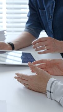 Business people collaborating on a project, analyzing financial data and statistics from printed charts and a digital tablet during a serious office meeting
