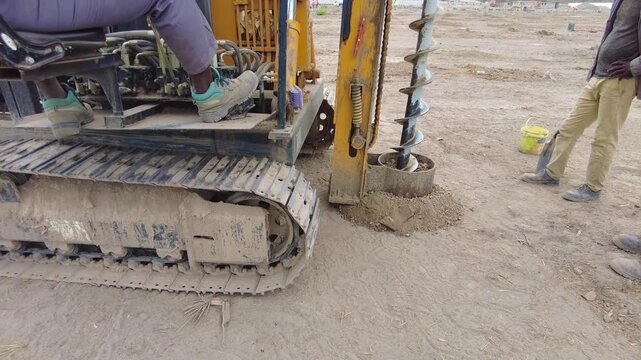 Slow motion of drilling rig digging the foundation for solar array concrete piles at Jambur Solar Plant in The Gambia, West Africa