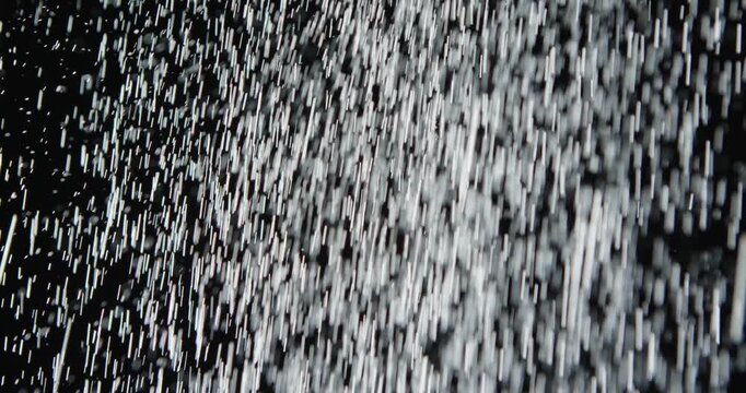 Tiny snow or dust randomly flying in the smoky air, empty space template for objects advertisement. Many dust particles cloud of white powder in low light on empty dark black contrast background.