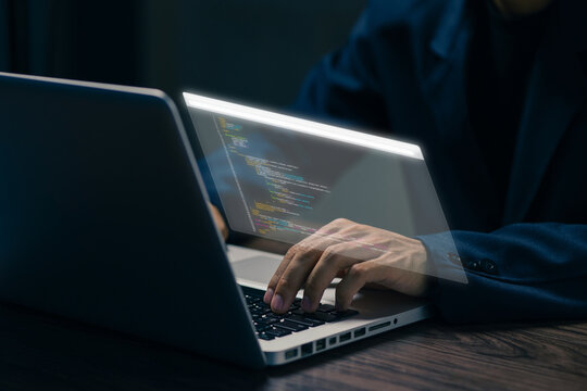 Business professional typing on a laptop with a virtual coding interface, representing software development, programming, data technology, digital transformation, and modern IT work.