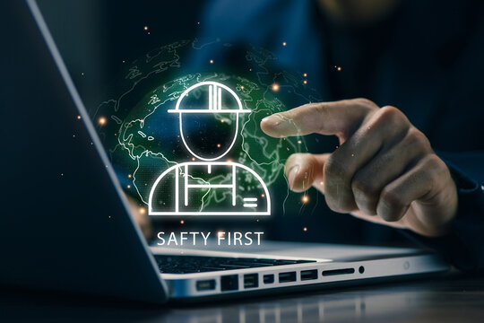 Business professional using a laptop with a virtual global safety interface, representing workplace safety, risk management, employee protection, compliance, and secure digital operations.