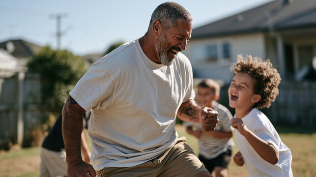 Energetic Maori grandparent in casual clothing performs a playful haka stance making grandchildren erupt in laughter on a grassy backyard, cultural identity celebration and joyful