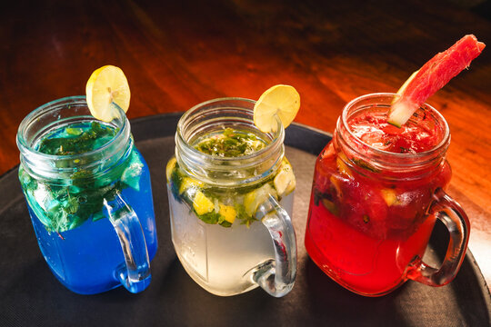 Refreshing and colorful healthy cool drinks served with fresh lemon slices and watermelon garnish. A vibrant summer beverage concept representing freshness, hydration, natural ingredients, healthy lif