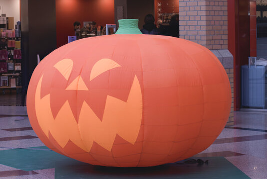 Large inflatable pumpkin with a face displayed in a shopping mall during the Halloween season - Netherlands. Eindhoven 26-10-2025