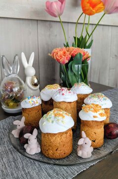 Baked goods with frosting and spring flowers arranged on a table in a home setting during daytime Easter celebration