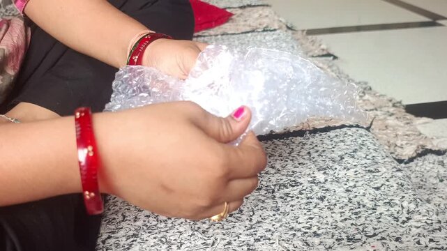 Close up of hands popping plastic bubble wrap packaging material