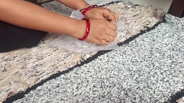 Close up of hands popping plastic bubble wrap packaging material