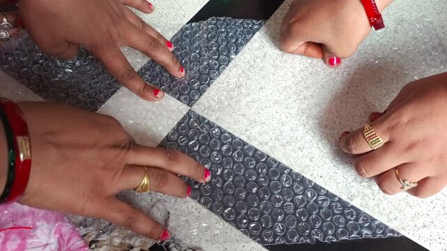 Close up of hands popping plastic bubble wrap packaging material