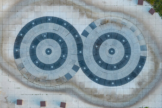 Aerial view of a circular fountain with two interlocking rings in a park setting in Poland.
