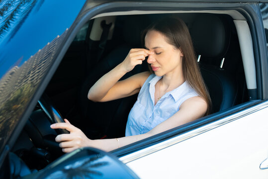 Woman driver with headache or sinus pain sitting in car during daily commute