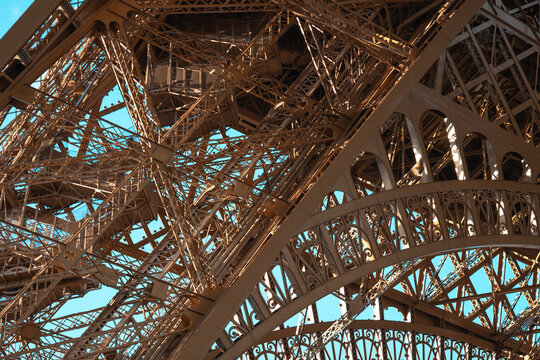 Eiffel tower iron lattice structure against blue sky, abstract view of iconic parisian landmark architecture