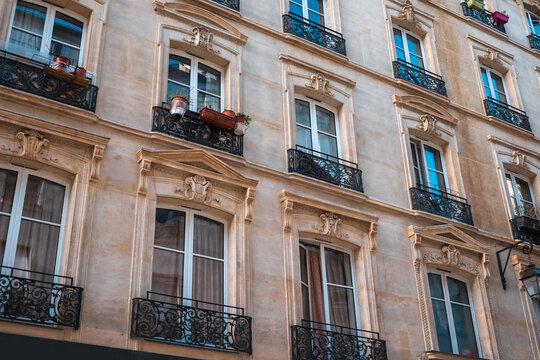 Haussmann building facade in paris featuring decorative balconies and ornate stone architecture, urban travel destination