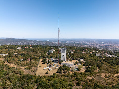 Aerial view of iconic radio and tv tower above Budapest's forested Buda Hills