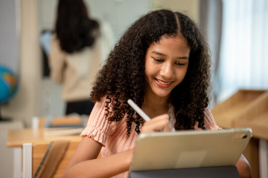 African American schoolgirl learning in classroom at elementary school. 