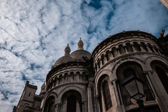 Sacre-coeur basilica domes and intricate facade against cloudy sky, iconic paris landmark in montmartre