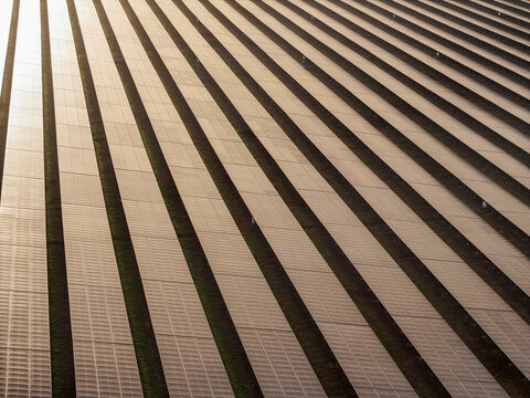 Aerial view of a large solar farm with rows of photovoltaic panels reflecting sunlight in San Pedro de Macoris, San Pedro de Macoris, Dominican Republic.