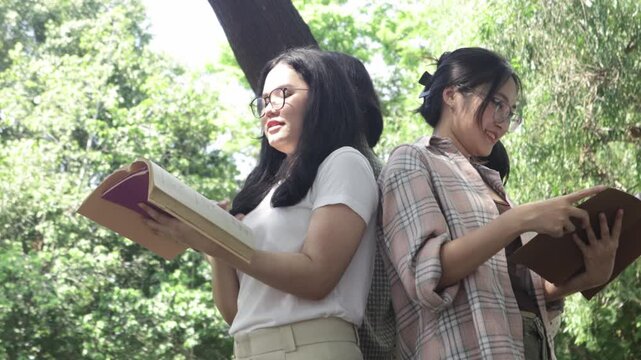Group students stand circle reading backs turned toward one another symbolizing shared goal academic success commitment pursuit knowledge amidst natural setting bathed in bright sunlight.