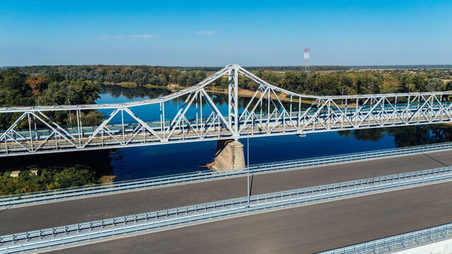 Aerial view of Racha Bridge spanning the Sava River with lush green forests and clear blue sky in Sremska Raca, Vojvodina, Serbia.