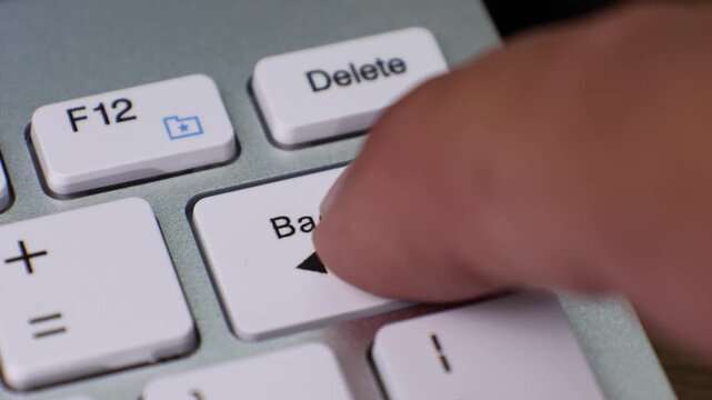 Keyboard keys including the Backspace key highlighted. Backspace key features an arrow pointing left, located near the Delete and F12 keys.