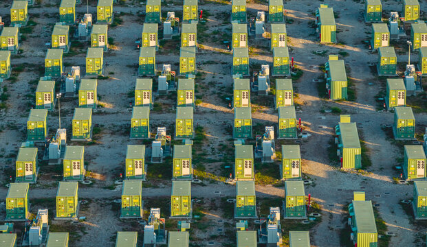Aerial view of multiple containerized battery storage units and electrical equipment arranged in regular rows at an energy storage facility in Trino, Piedmont, Italy.