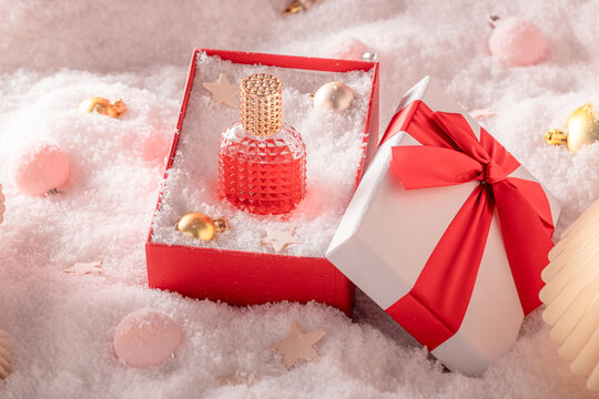 Sweet perfume is shown outside in chilly Christmas winter landscape.
