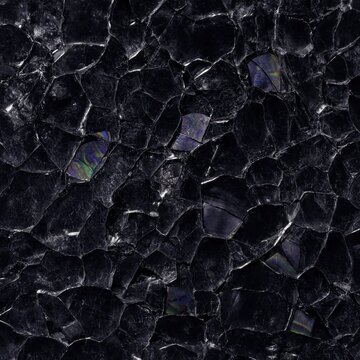 Close-up texture of fractured black obsidian glass with sharp edges and subtle iridescent rainbow reflections.