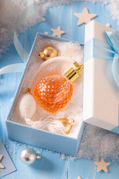 Nice perfume is poured carefully into handsome Christmas glass container.