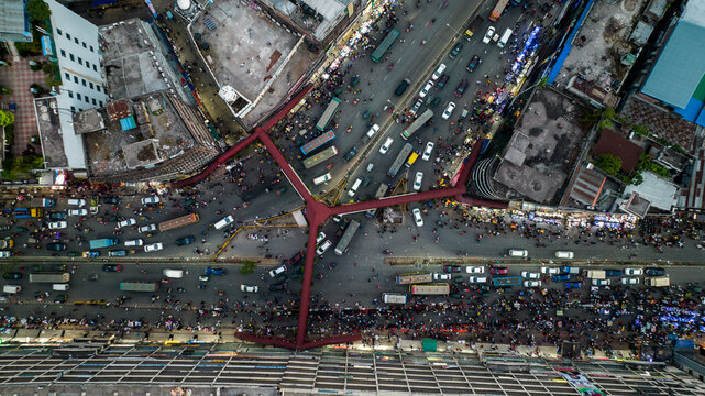 Aerial view of a bustling urban intersection with dense traffic, numerous vehicles, and pedestrians navigating the busy streets in Dhaka, Dhaka Division, Bangladesh.