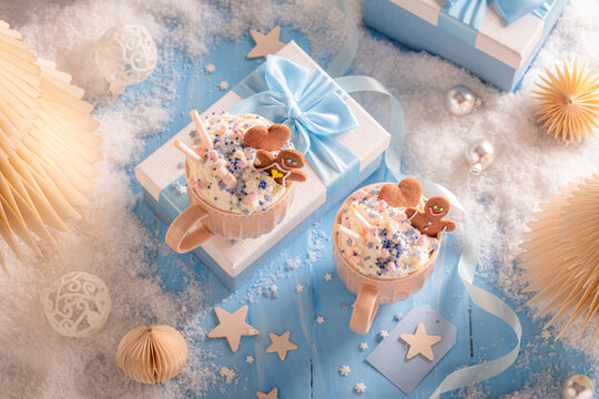 Ribbon bow adorning mug of hot chocolate served with gingerbread.
