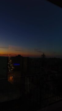 View of a christmas tree over a window of a house in the city