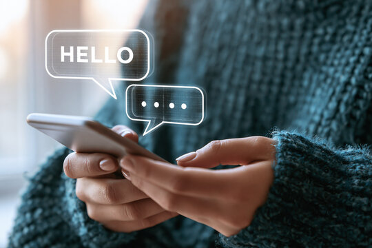 A person using a smartphone to send text messages with floating digital chat bubble graphics.