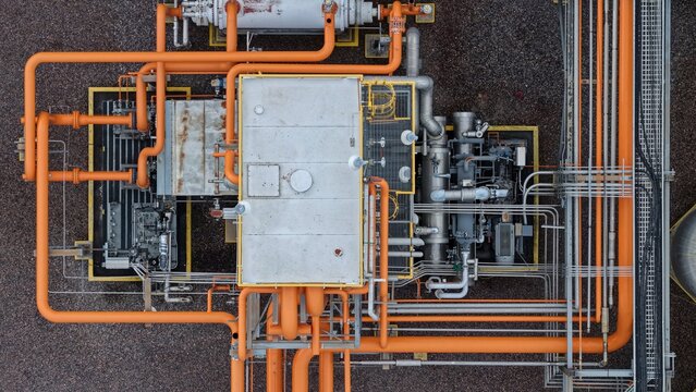 Aerial view of industrial machinery and orange pipelines at a facility in Englewood, Colorado, United States.
