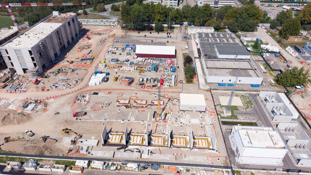 Aerial view of the Equinix MLSS1 data center construction site featuring industrial buildings, cranes, and foundation work in Castelletto, Lombardia, Italy.