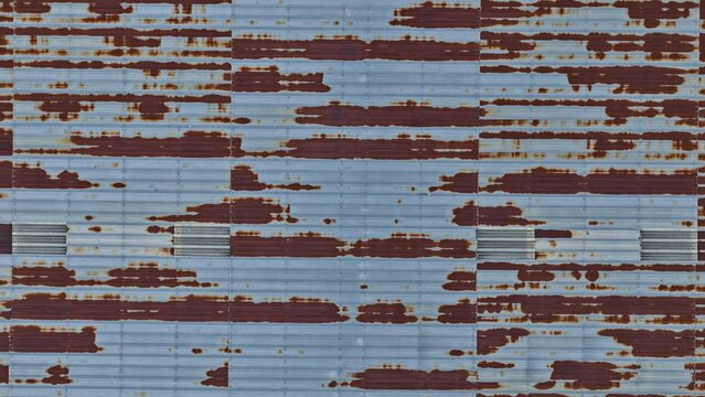 Aerial view of a weathered corrugated metal roof featuring extensive rust patterns and linear textures in Englewood, Colorado, United States.