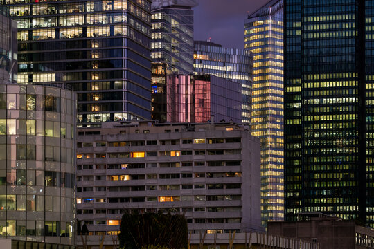 Office towers in an urban landscape at dusk in La Defense district of Paris France showing contemporary architecture and illuminated city windows