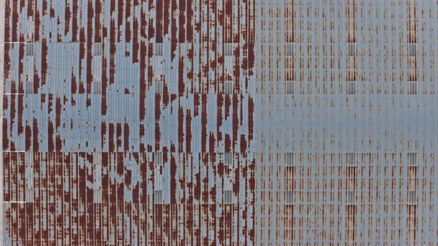 Aerial view of a weathered corrugated metal roof with significant rust patterns and vertical lines in Englewood, Colorado, United States.