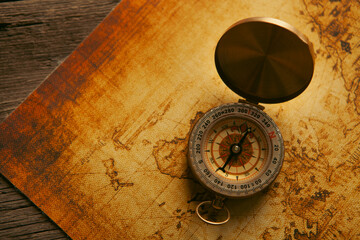 Compass and old map on wooden background. Vintage style toned picture © Artvibe