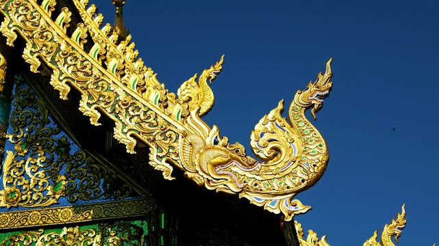 Slow Motion Close-Up of Golden Naga Gable Ornament on a Thai Temple Roof