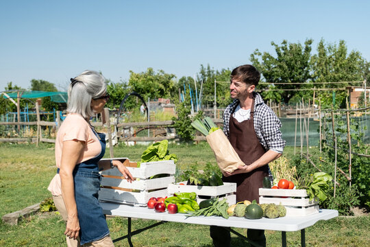 Farmers selling fresh fruit and vegetables from their community garden booth