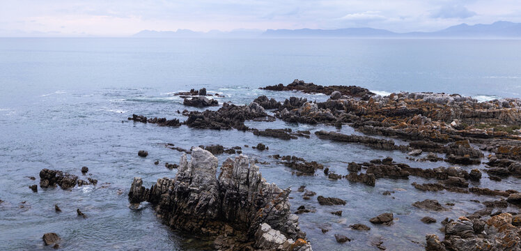 stormy late afternoon light on rocky coastline of DeKelders, South Africa