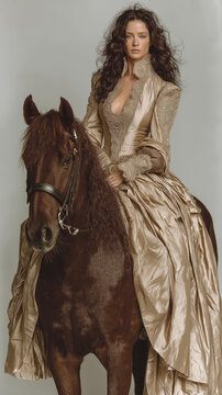 Ethereal Elegance: A stunning woman adorned in a majestic golden gown gracefully rides a dark brown horse, exuding an aura of timeless beauty and regal poise.