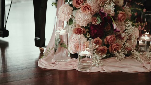 Elegant floral centerpiece with roses, hydrangeas, and floating candles, creating a warm ambiance for a special event