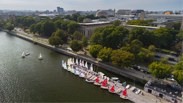 Aerial view of sailing boats docked at a pier on the Charles River with the MIT campus and Great Dome in the background in Cambridge, Massachusetts, United States.